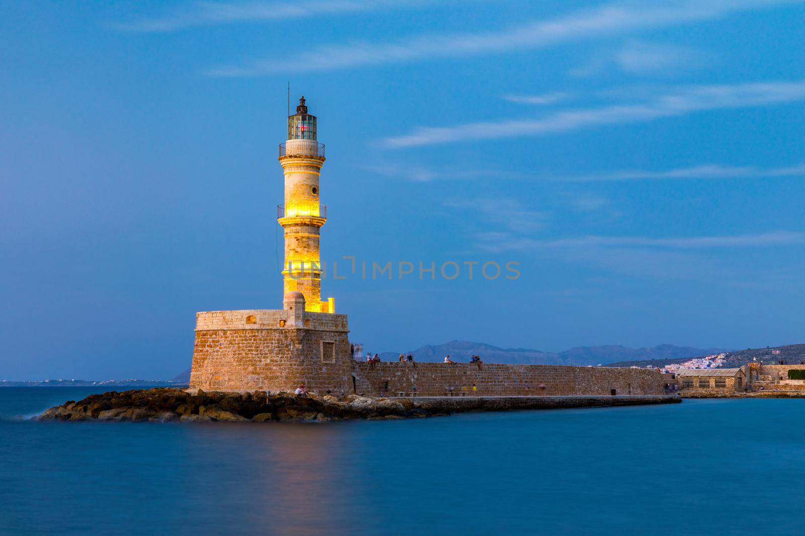 Venetian harbour and lighthouse in old harbour of Chania at sunset, Crete, Greece. Old venetian lighthouse in Chania, Greece. Lighthouse of the old Venetian port in Chania, Greece.