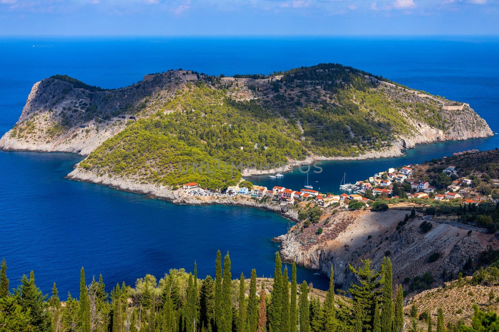 Assos village in Kefalonia, Greece. Turquoise colored bay in Mediterranean sea with beautiful colorful houses in Assos village in Kefalonia, Greece, Ionian island, Cephalonia, Assos village.