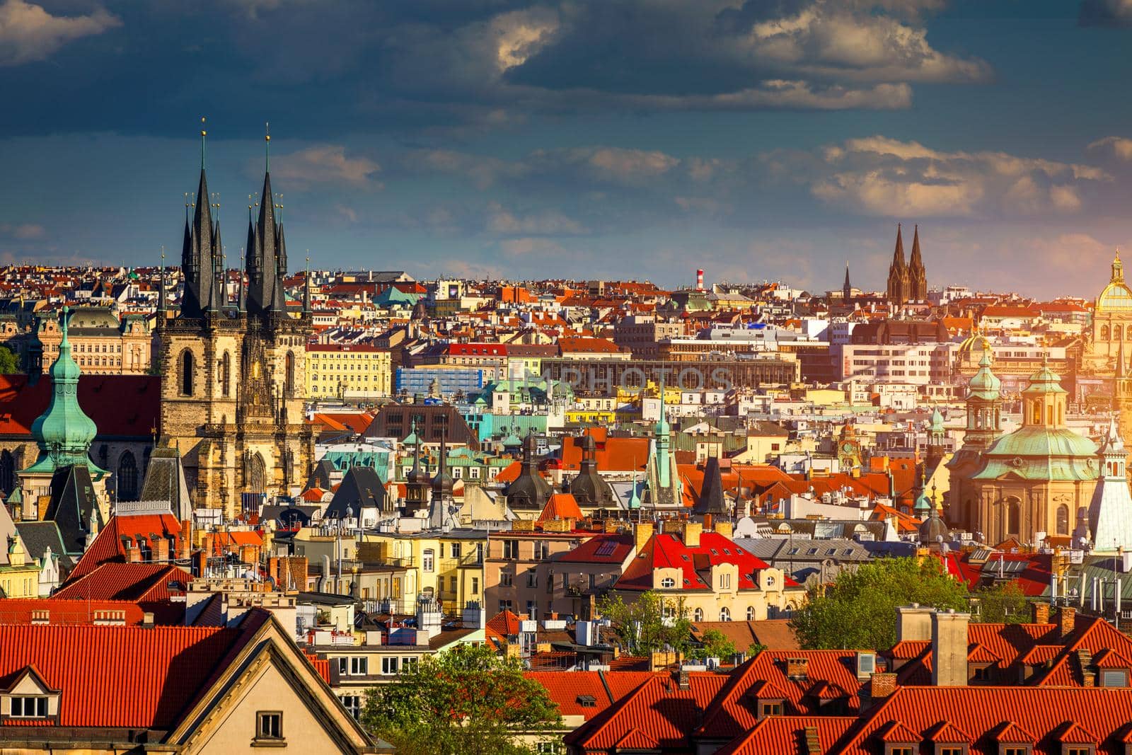 Prague red roofs and dozen spires of historical Old Town of Prague. Cityscape of Prague on a sunny day. Red rooftops, spires and the Charles Bridge and Vltava River in the background. Prague, Czechia.
