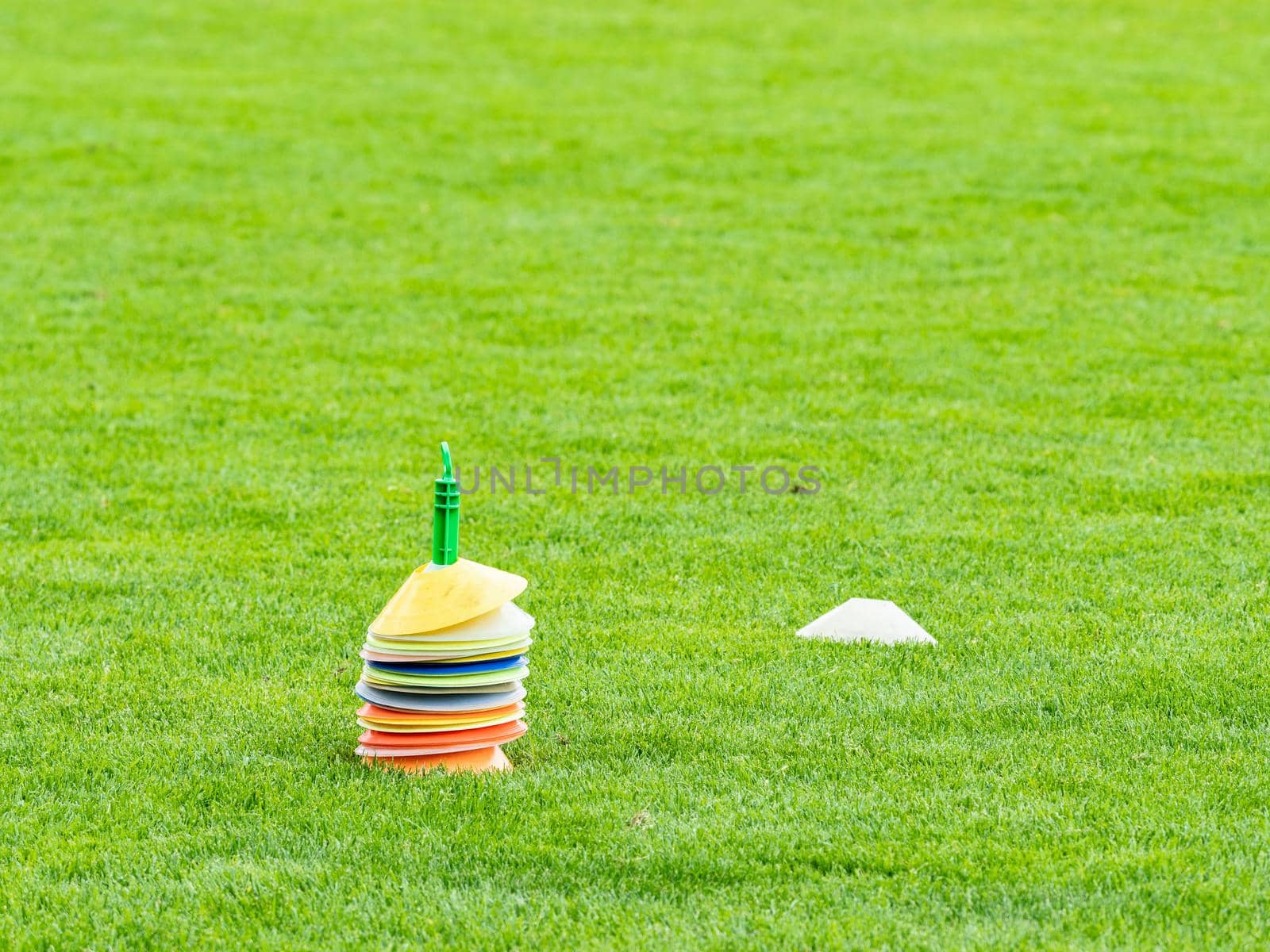 Colorful cones in football field. Coath arranged colorful markers in trainning grassfield of football soccer stadium 