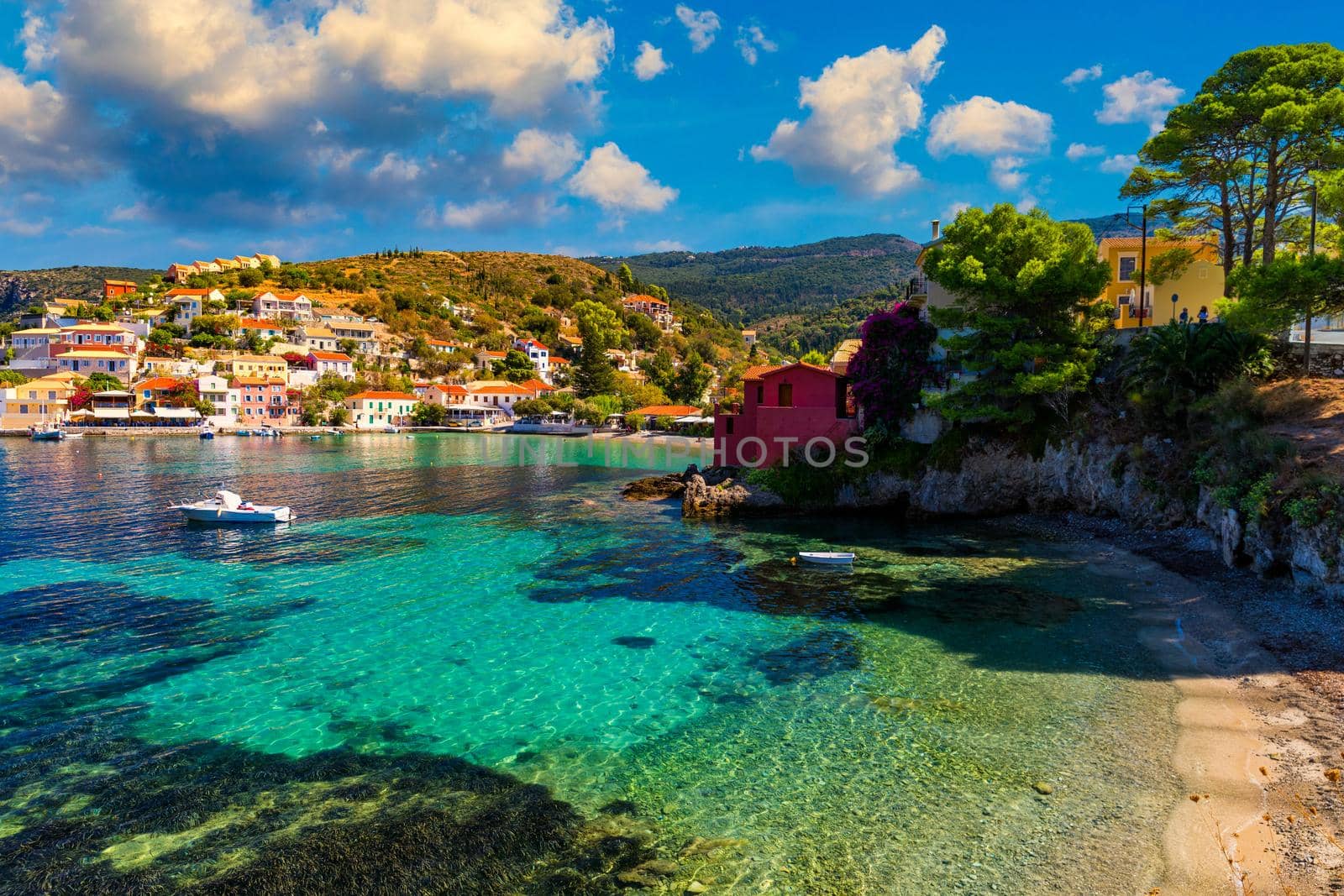 Assos village in Kefalonia, Greece. Turquoise colored bay in Mediterranean sea with beautiful colorful houses in Assos village in Kefalonia, Greece, Ionian island, Cephalonia, Assos village.