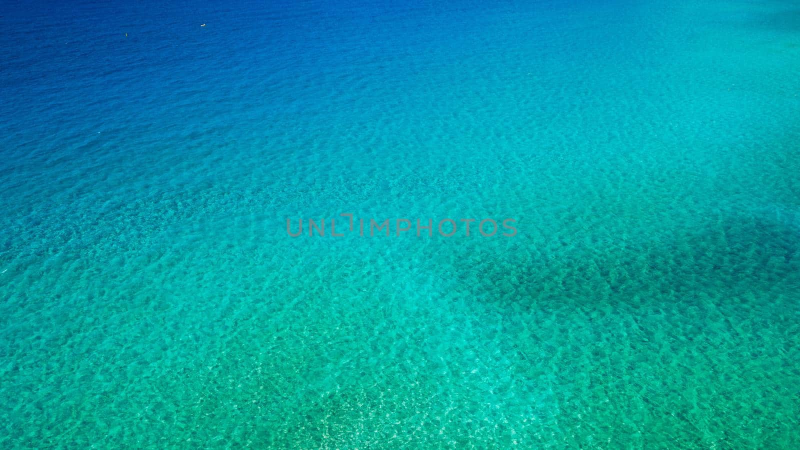 Sea surface aerial view. Background image of the turquoise sea. Deep sea and corals. Aerial drone shot of turquoise water, space for text. Aquamarine background. Sea Aerial view.