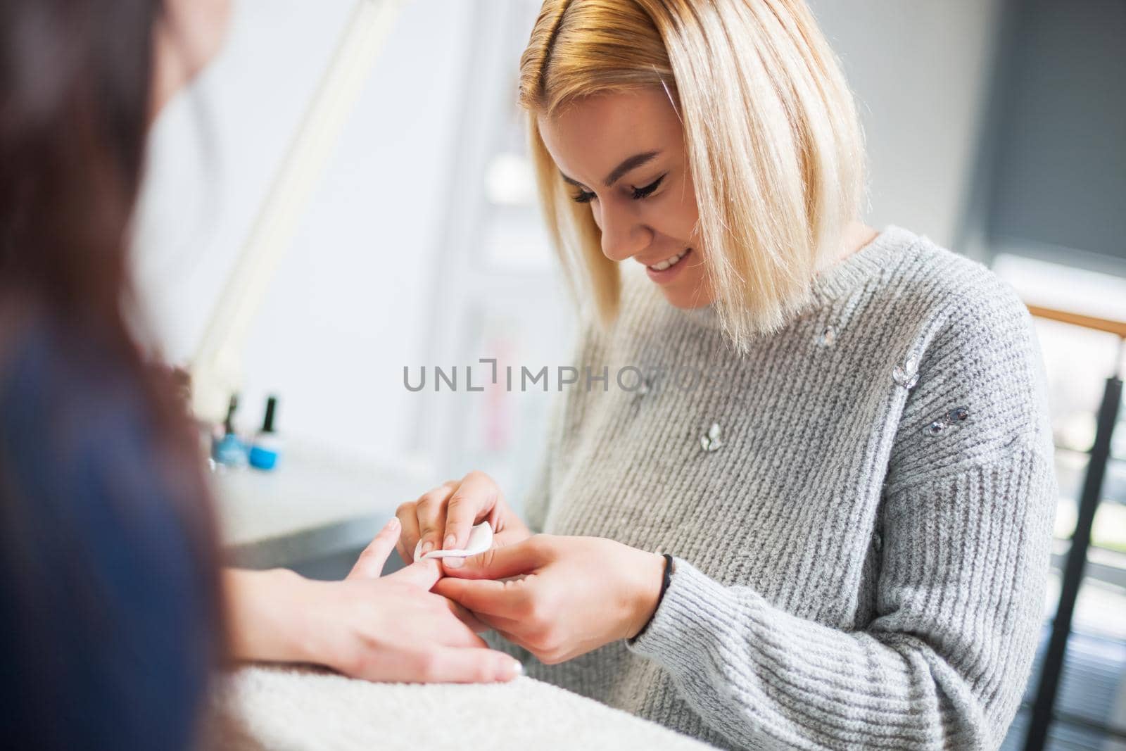 Manicure process at professional saloon. Nail treatment.