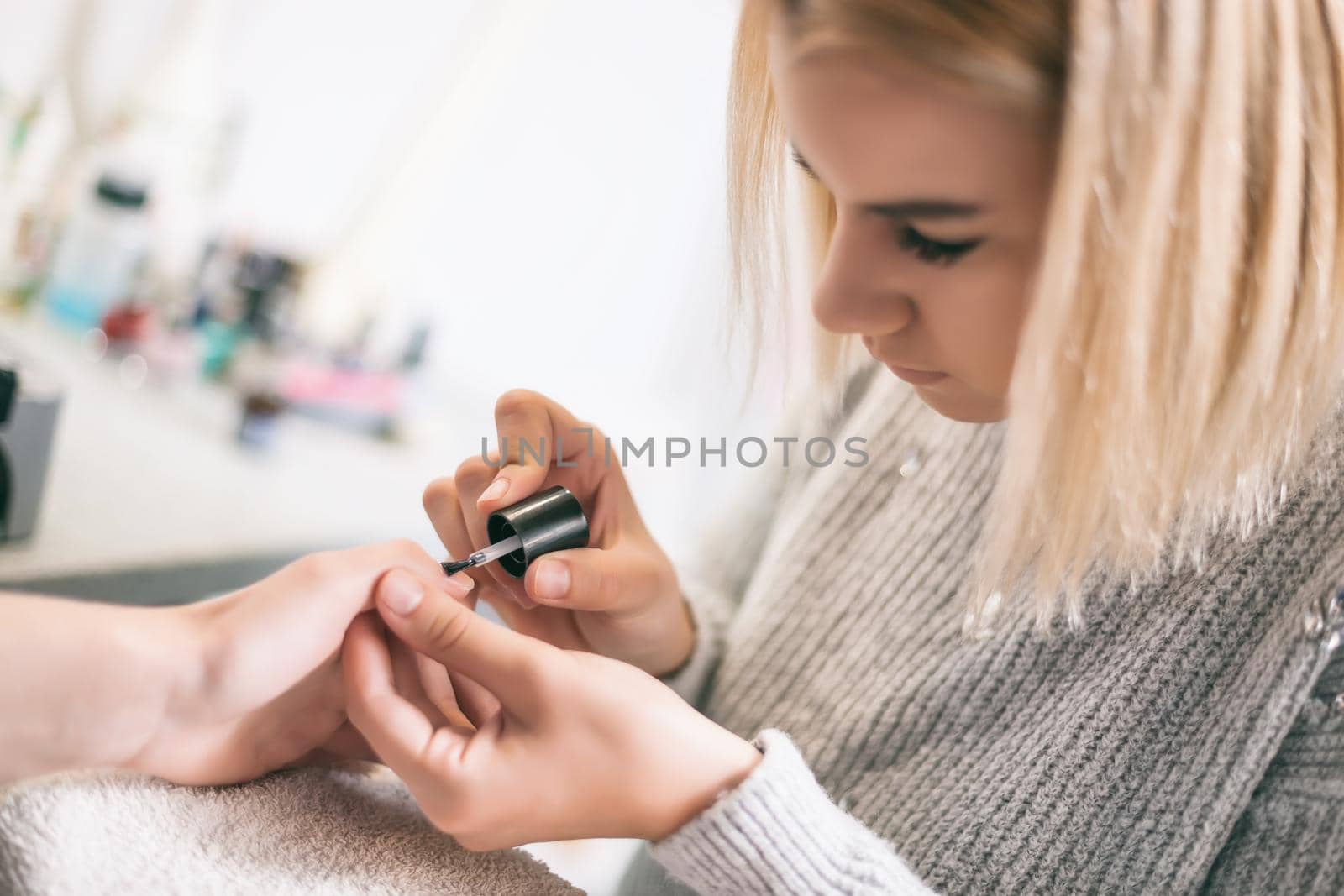 Manicure process at professional saloon. Nail treatment.