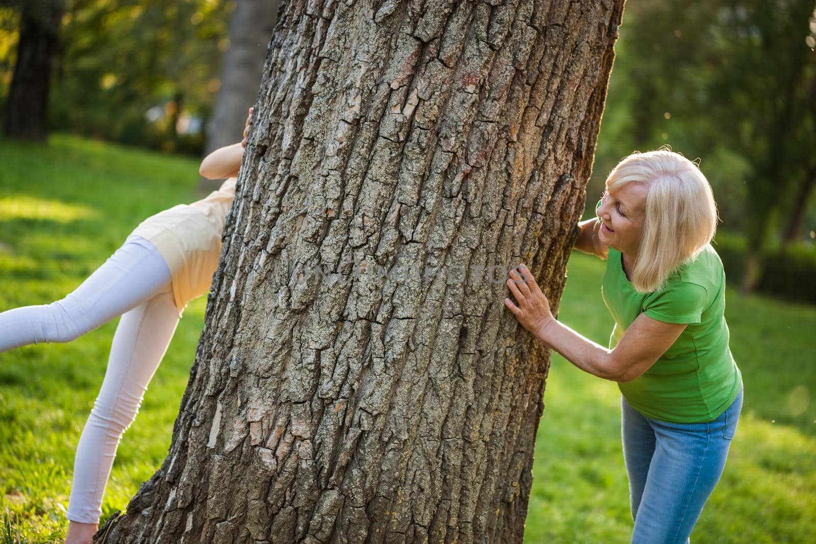 Grandmother and granddaughter are having fun together in park.