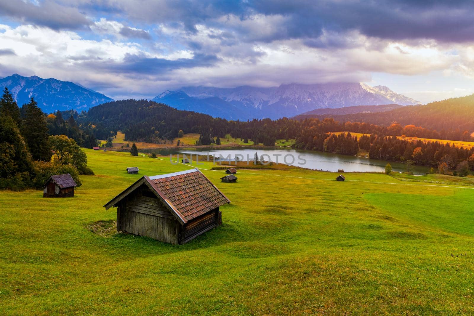 Panoramic morning scene of Wagenbruchsee (Geroldsee) lake with Zugspitze mountain range on background. Amazing autumn view of Bavarian Alps, Germany, Europe. Wooden hut on meadow by Geroldsee lake. 