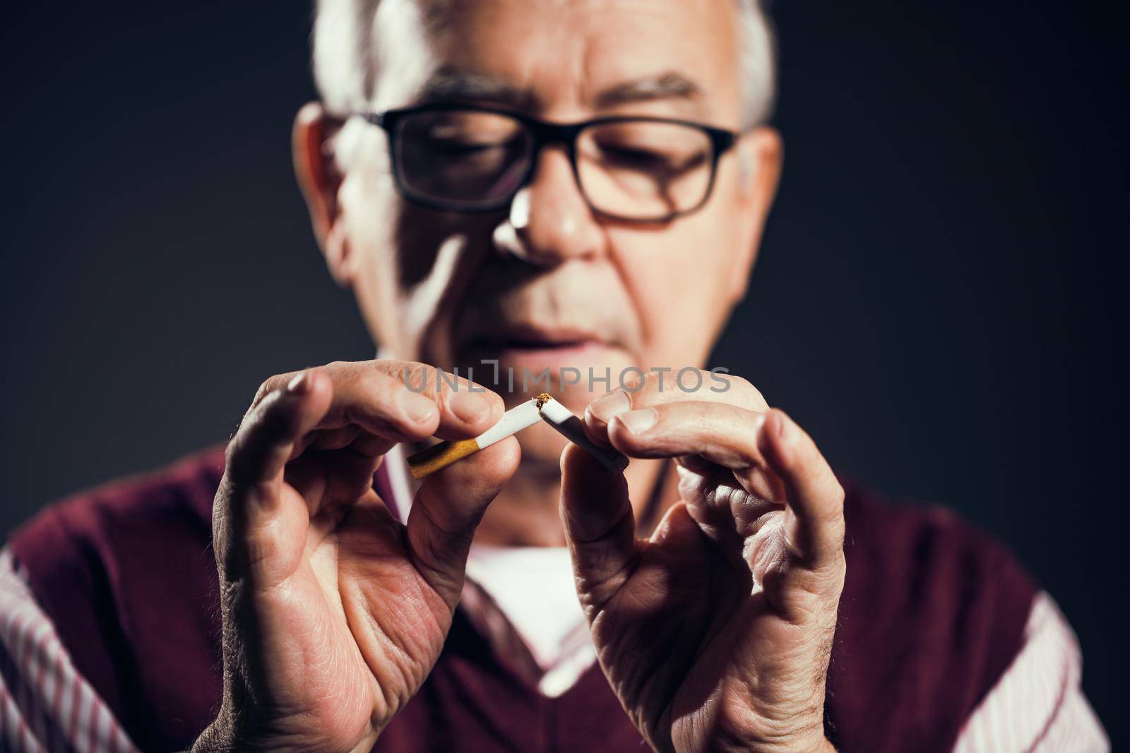 Close up image of senior man who is decided to quit smoking.