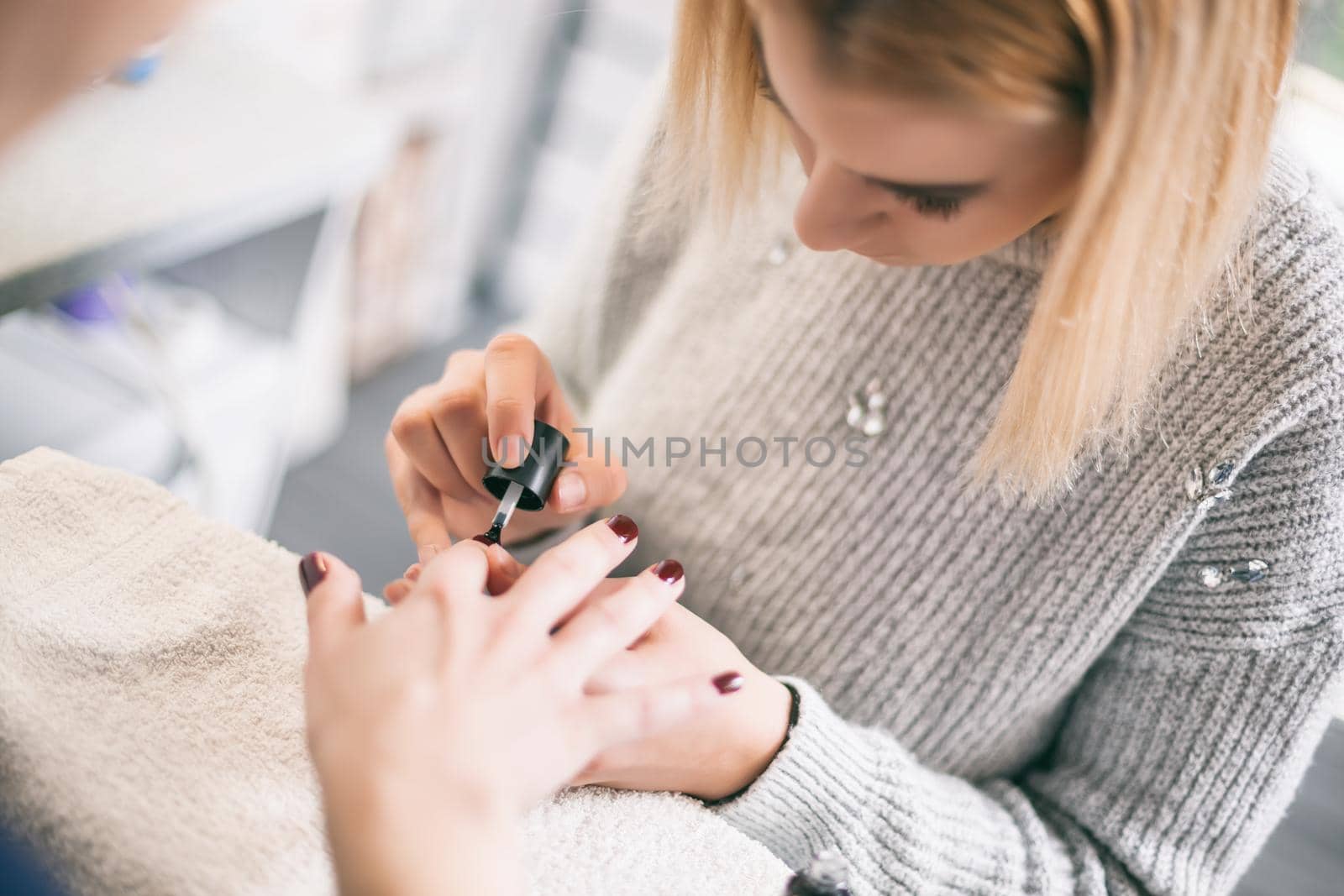 Manicure process at professional saloon. Nail treatment.