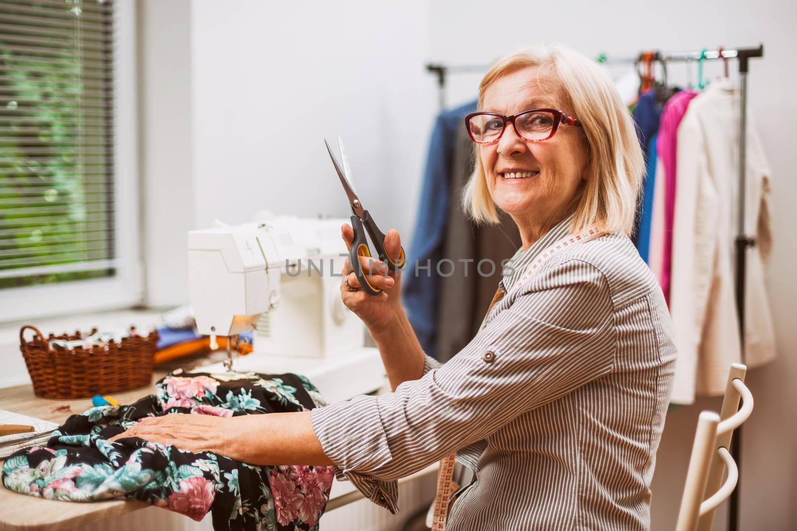 Adult woman is sewing in her studio.