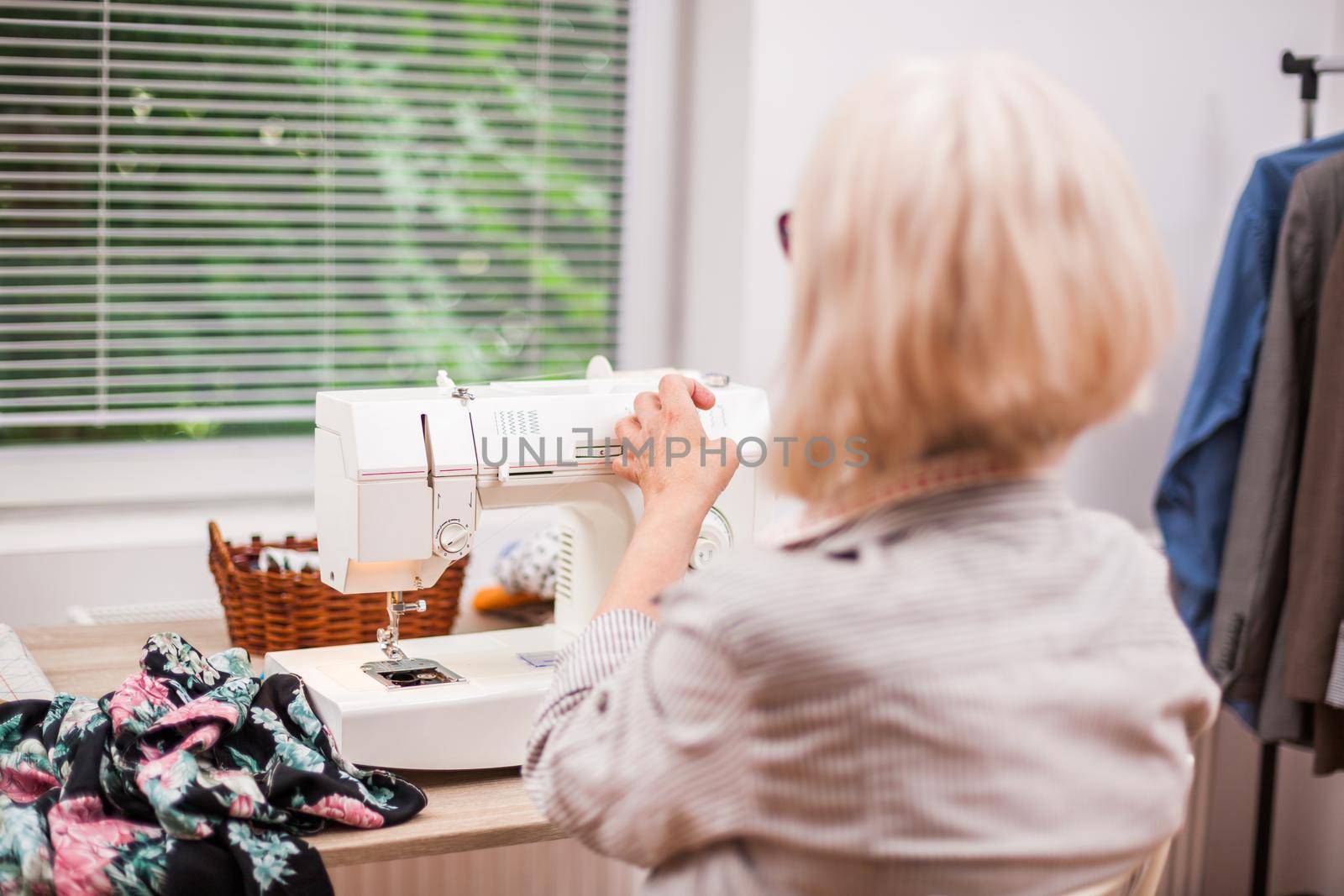 Adult woman is sewing in her studio.