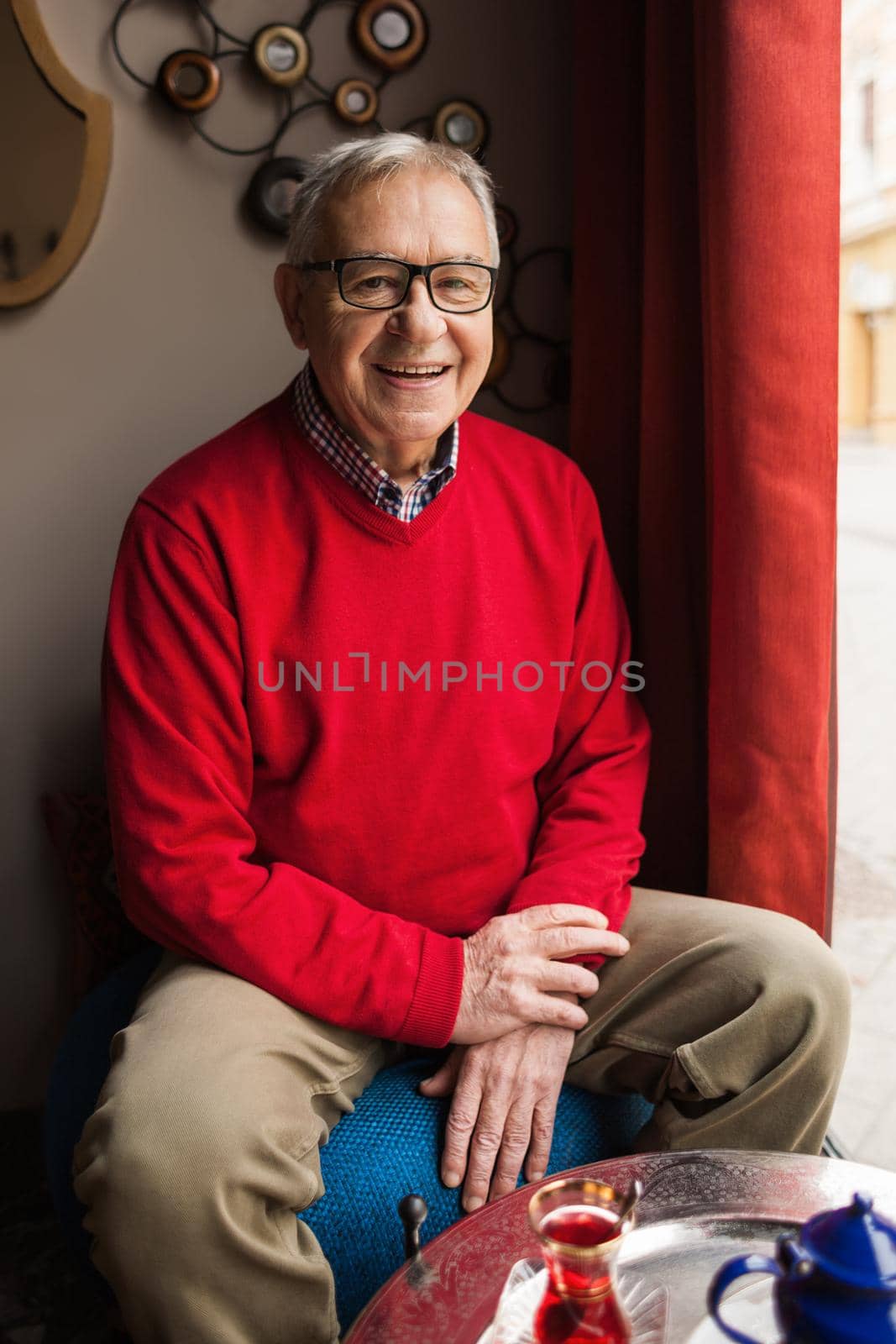 Portrait of happy senior man in a cafe.