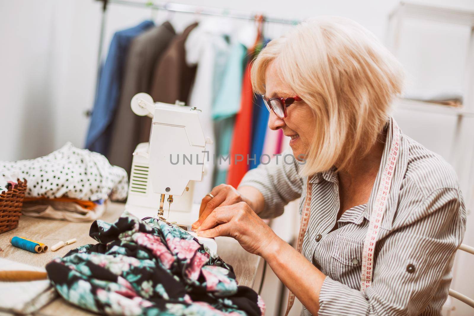 Adult woman is sewing in her studio. She is frustrated because she made a mistake.