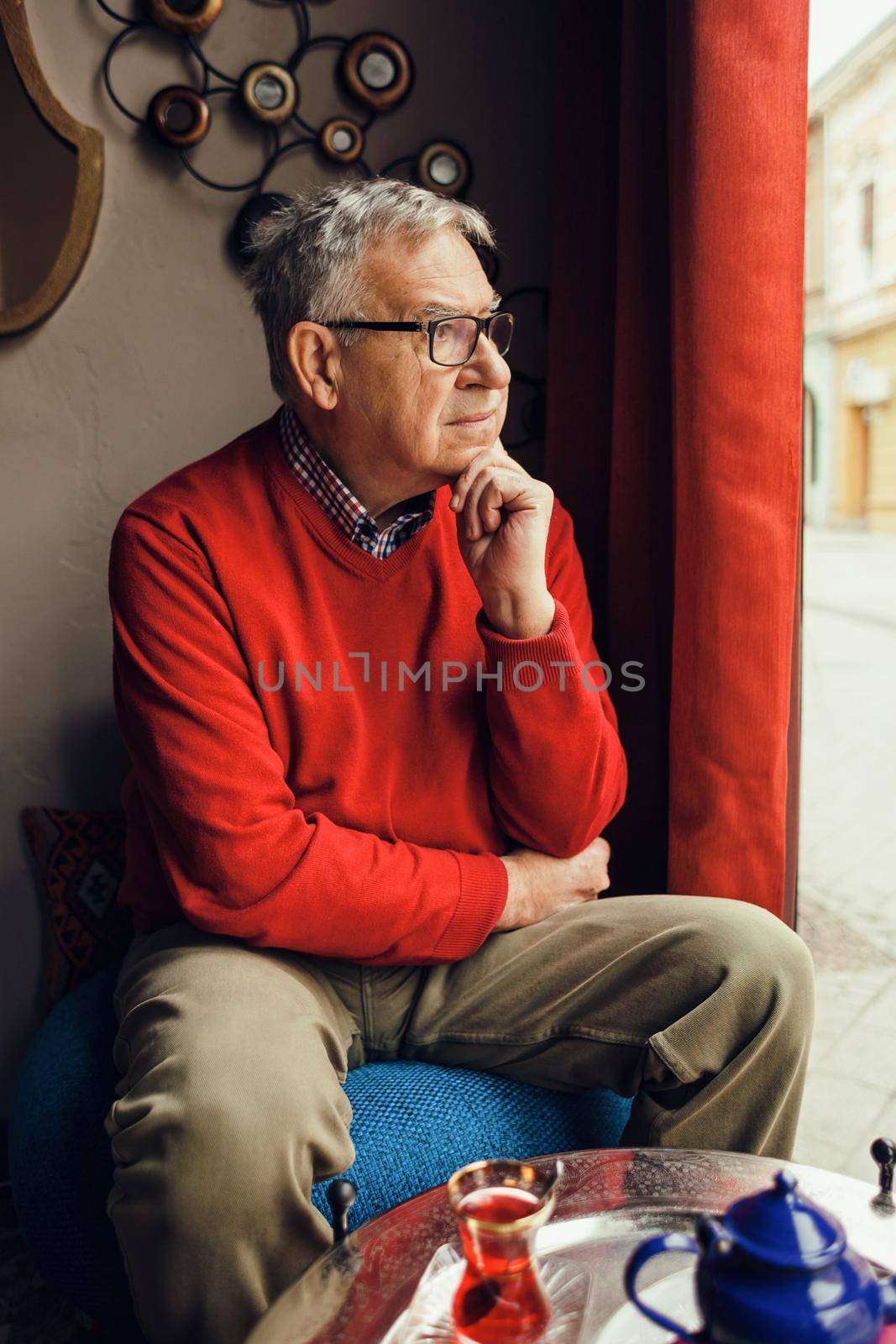 Portrait of worried senior man in a cafe.