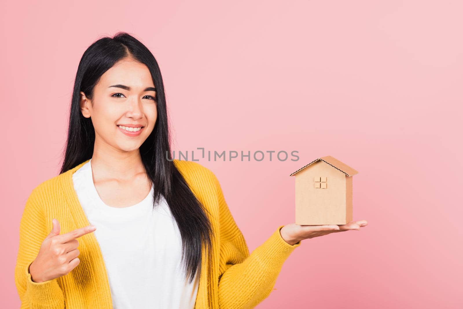 woman excited smiling holding house model on hand by Sorapop