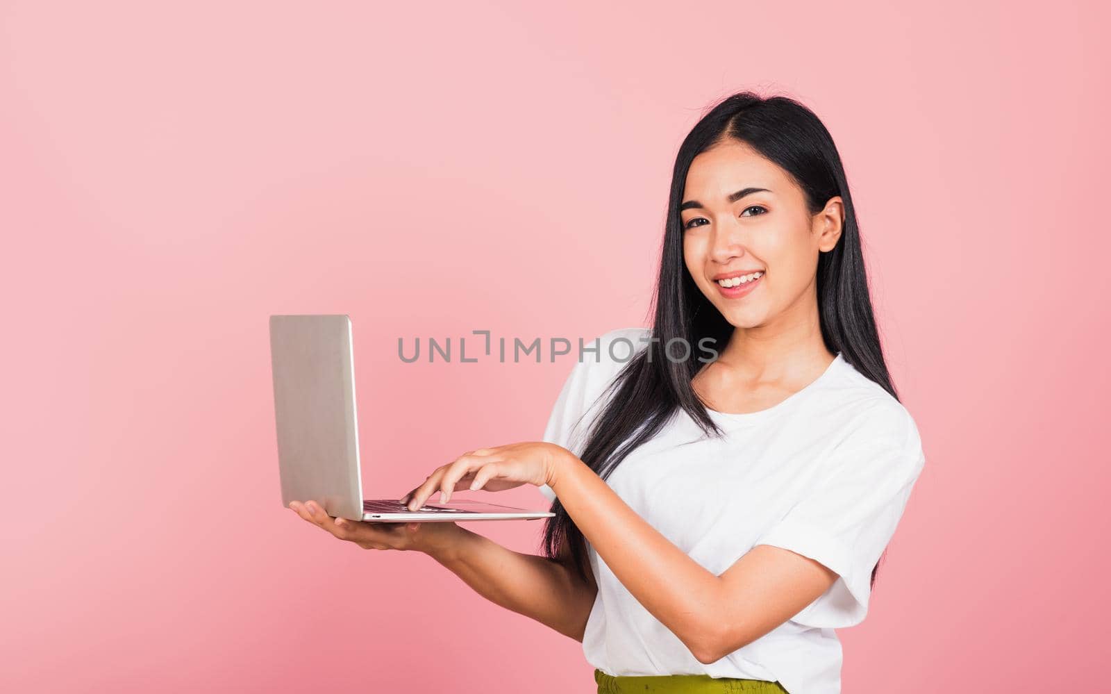 woman confident smiling holding using laptop computer and typing keyboard by Sorapop