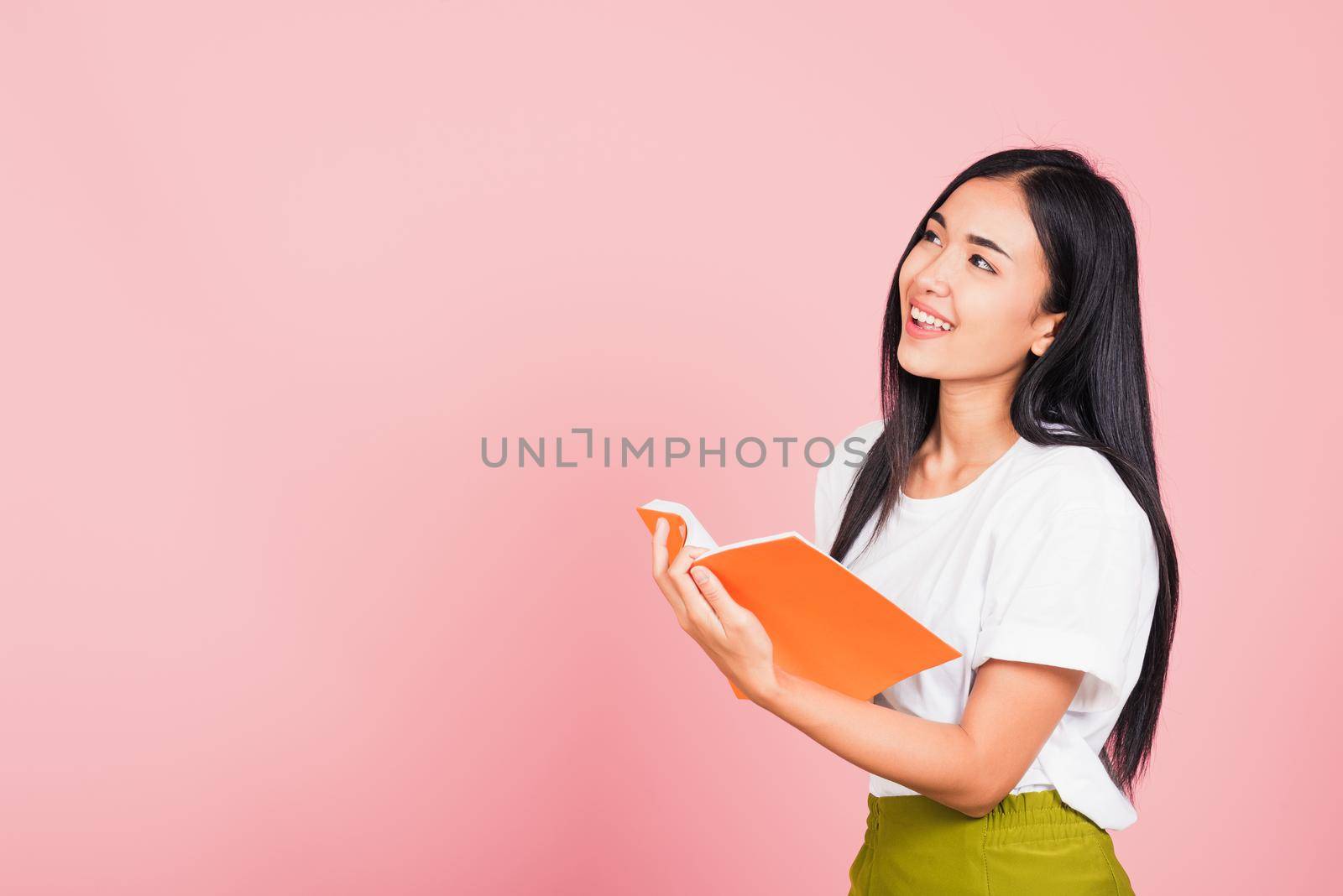 woman confident smiling standing holding orange book open by Sorapop