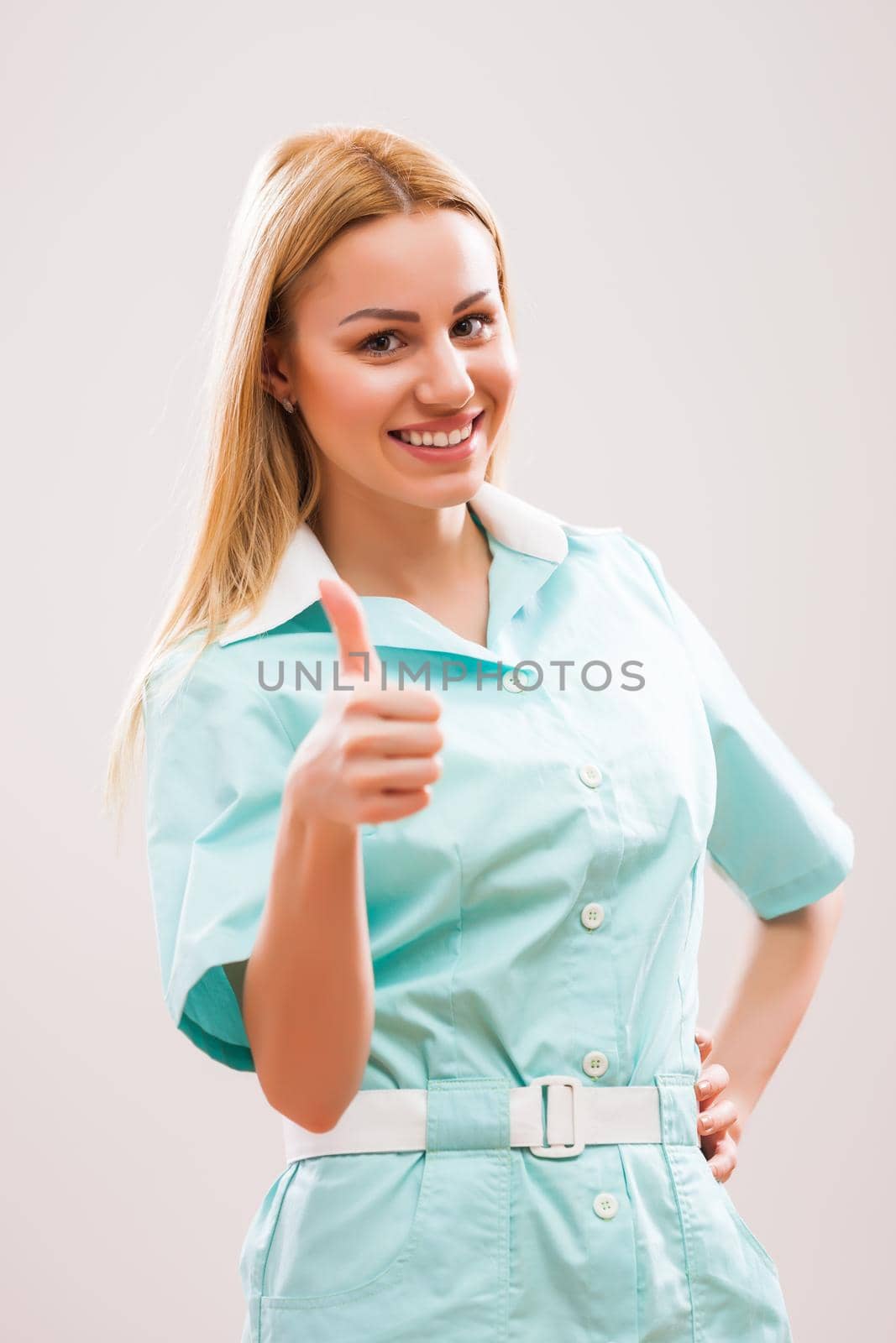 Portrait of happy young nurse showing thumb up.