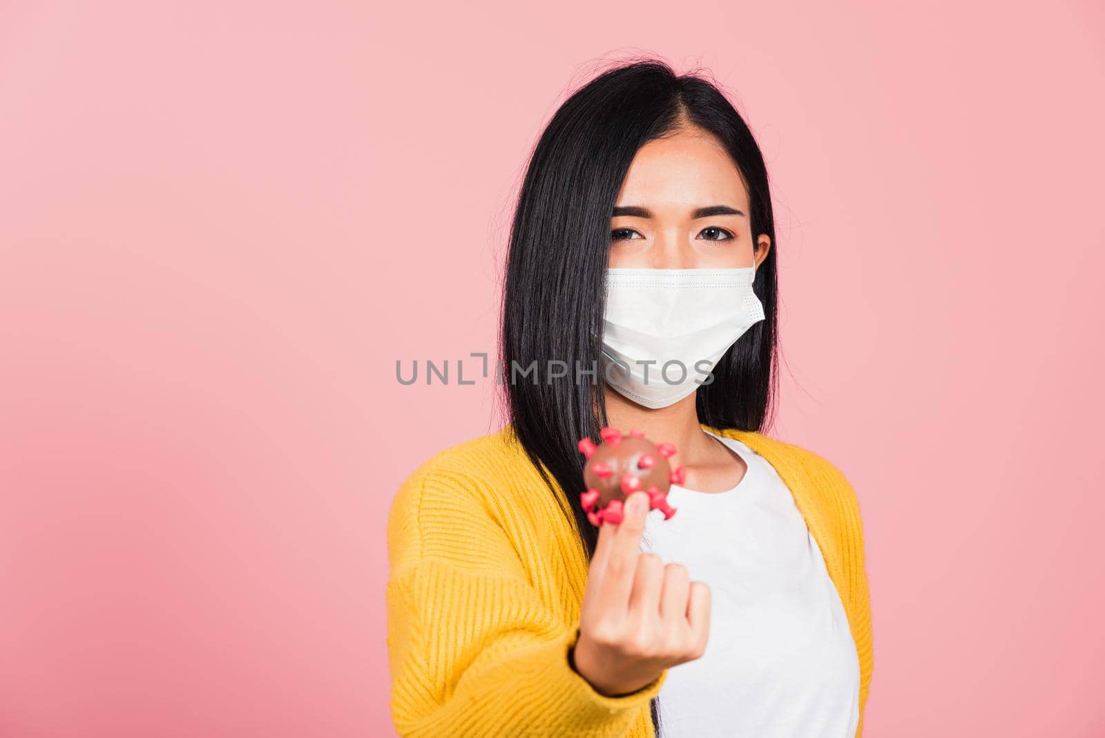 Portrait of Asian young woman wear face mask protective holding DNA strand of Coronavirus (COVID-19, 2019-ncov) genetic instruction, new strain RNA mutation, studio shot isolated on pink background