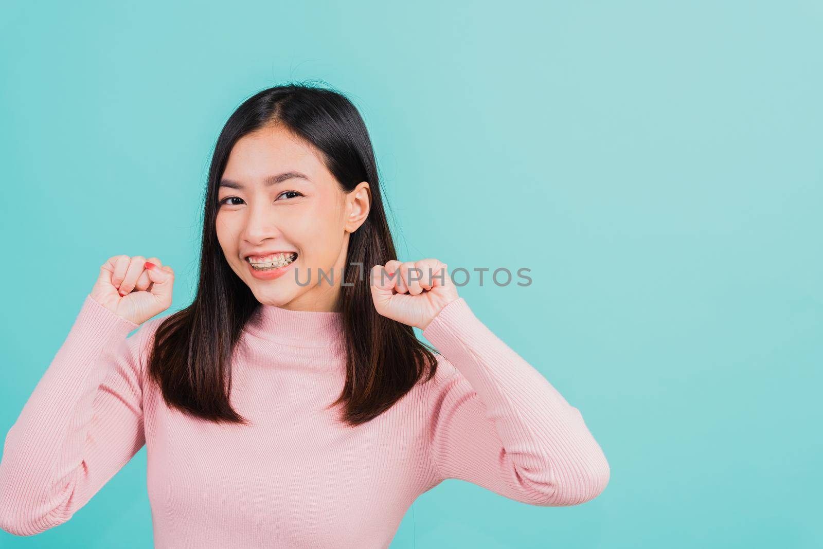 woman smiling wear silicone orthodontic retainers on teeth surprised she is excited screaming and raise hand make gestures wow by Sorapop