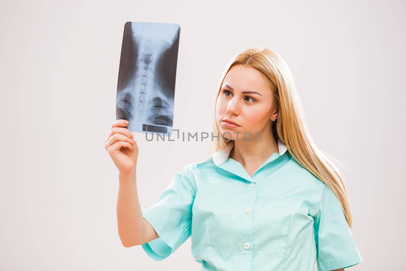 Portrait of young doctor who is looking at x-ray image.