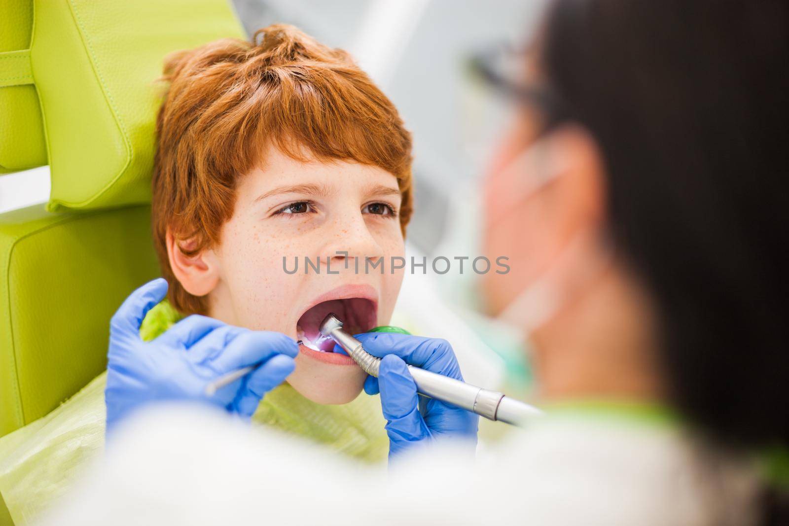 Dentist is repairing teeth of a little boy.