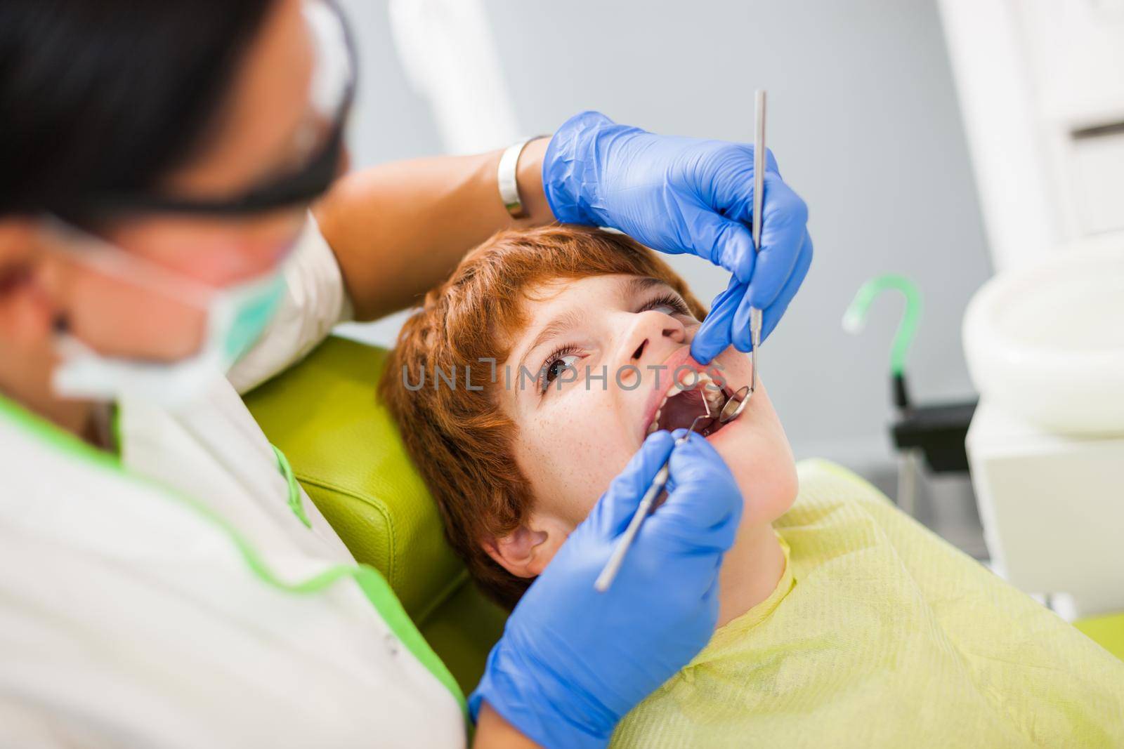 Dentist is repairing teeth of a little boy.