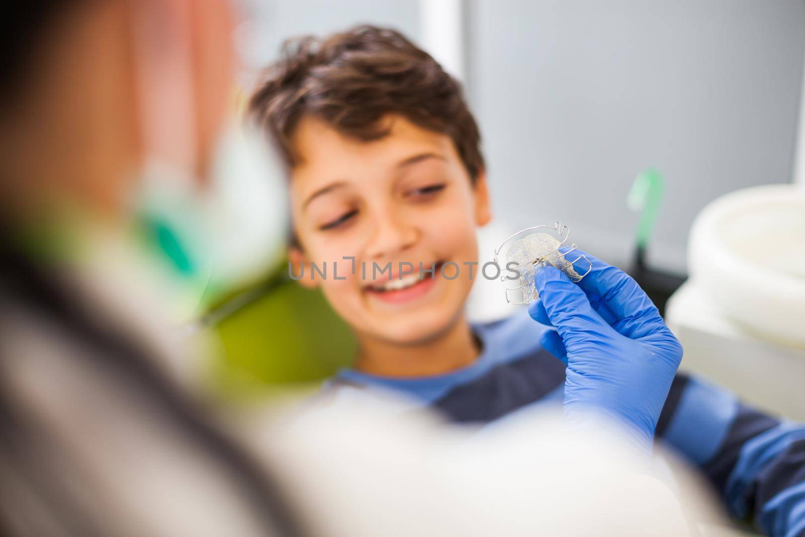 Dentist is teaching little boy about braces.