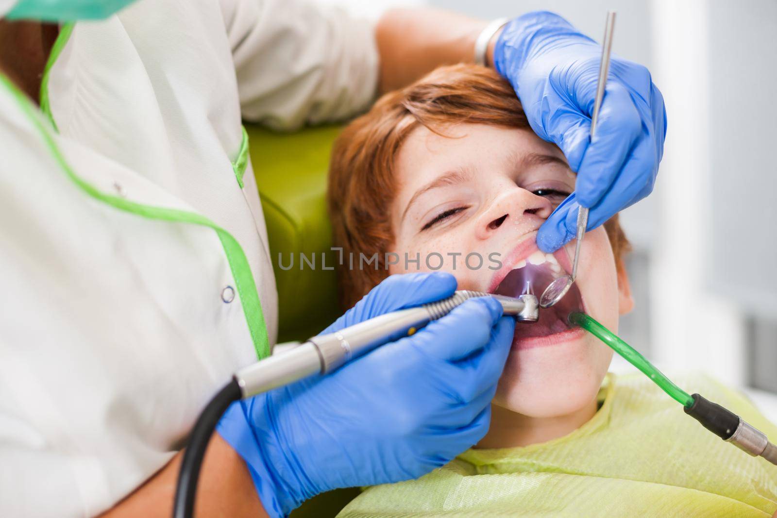 Dentist is repairing teeth of a little boy.