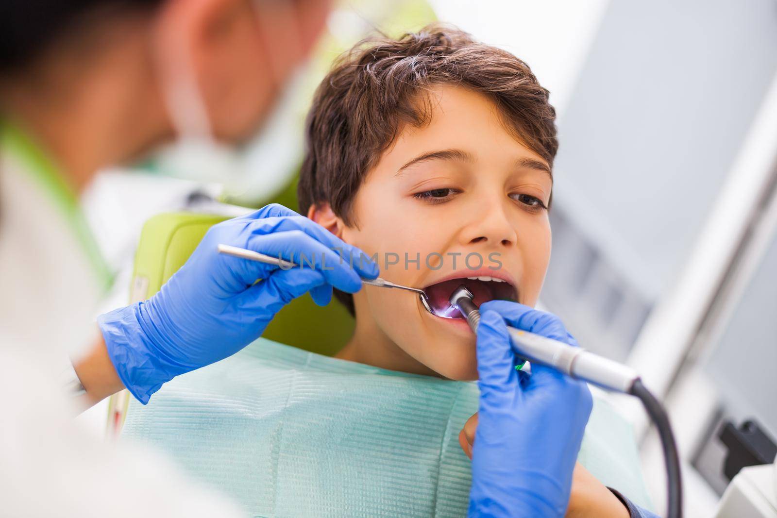 Dentist is repairing teeth of a little boy.