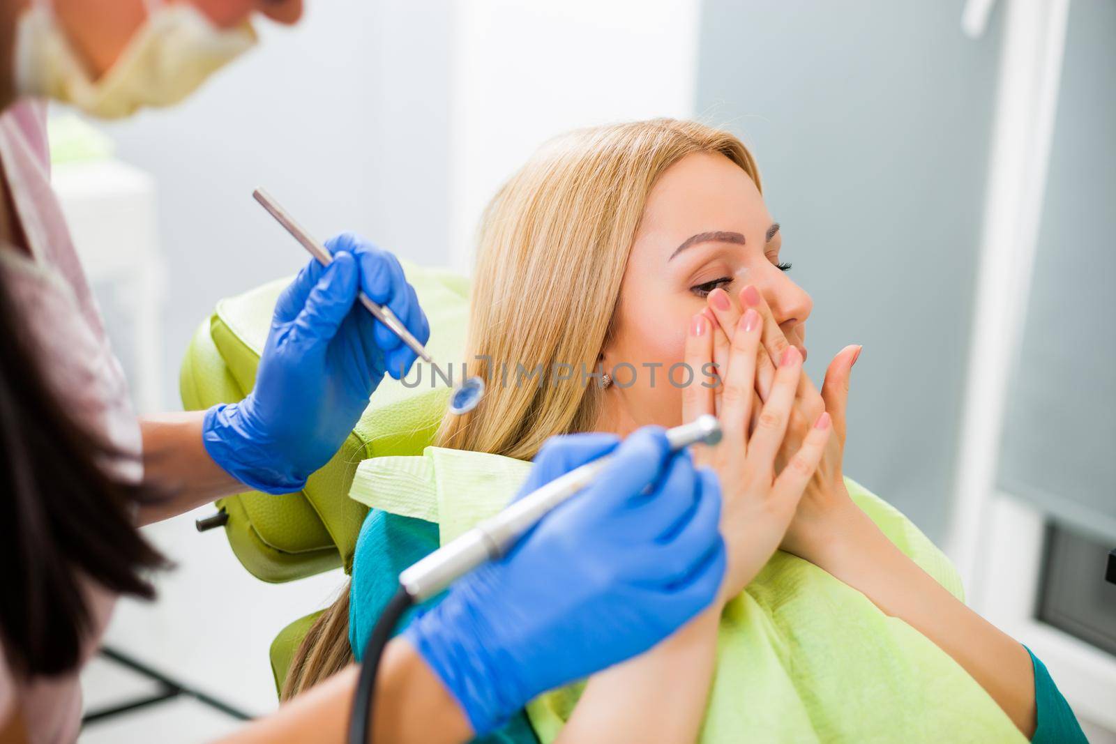 Young woman at dentist. She is afraid.