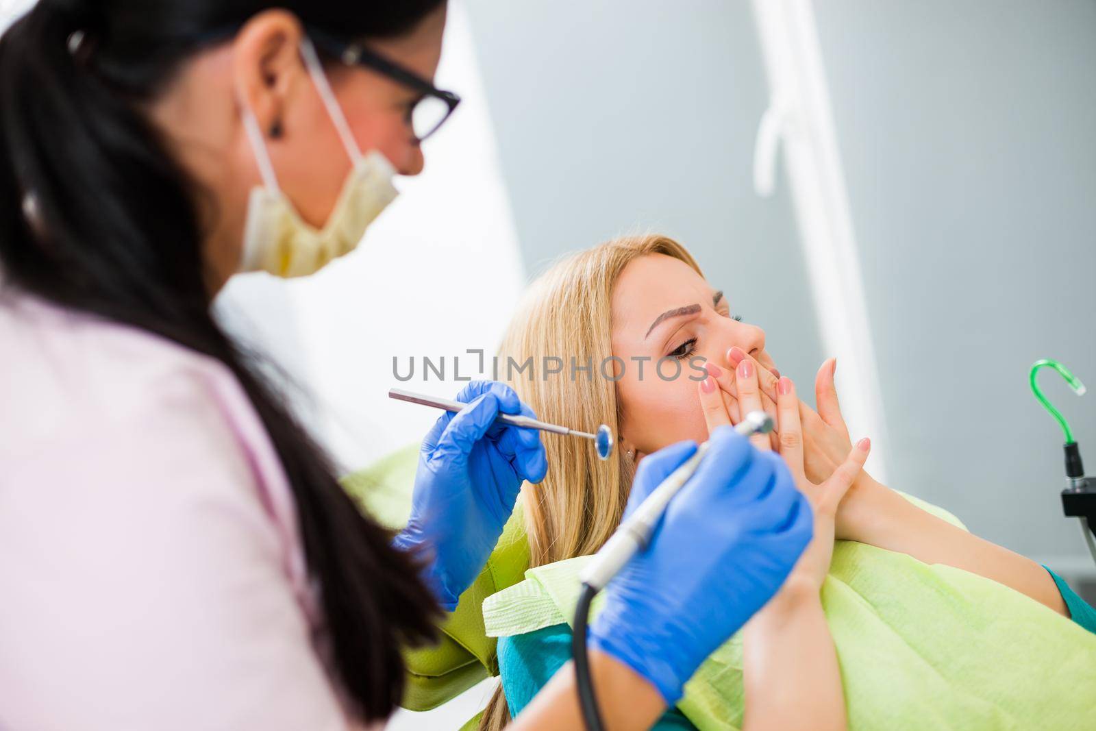 Young woman at dentist. She is afraid.