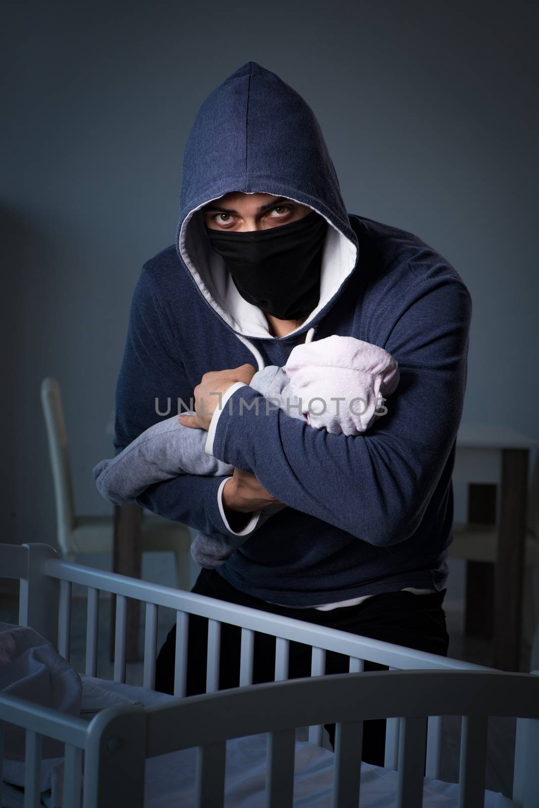 Criminal stealing baby in human child traficking concept