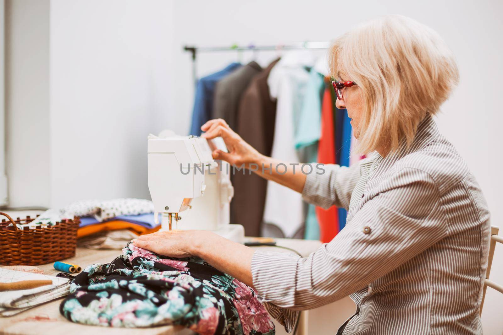 Adult woman is sewing in her studio.