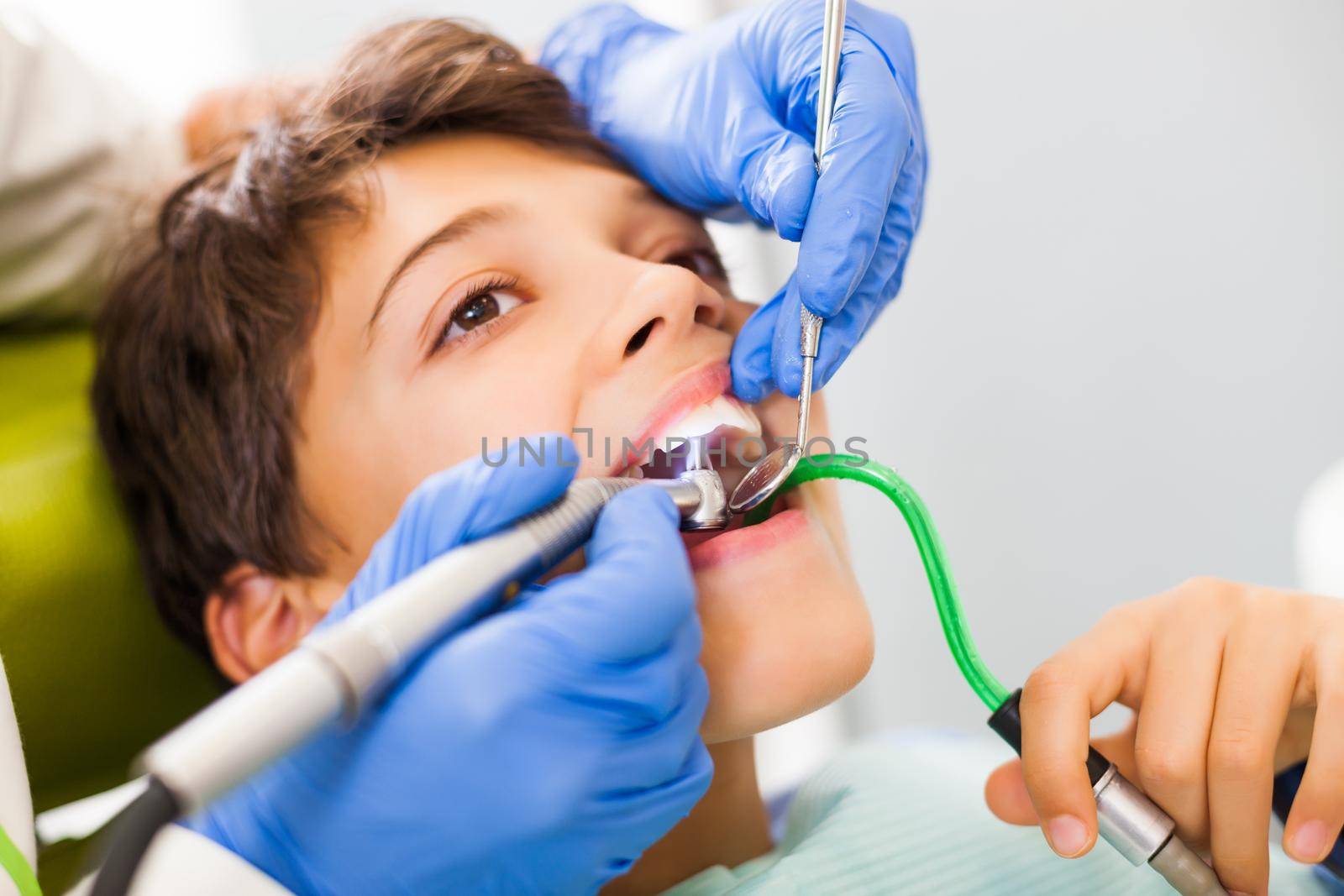 Dentist is repairing teeth of a little boy.