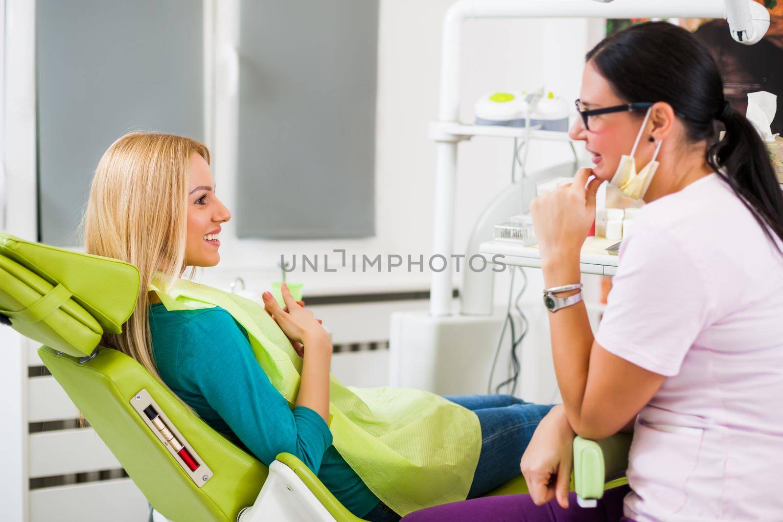 Happy young woman is talking to dentist.