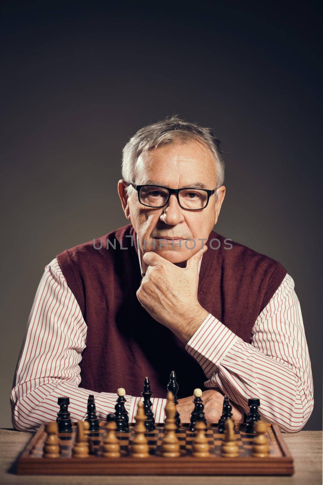 Portrait of senior man who is participating in chess game.