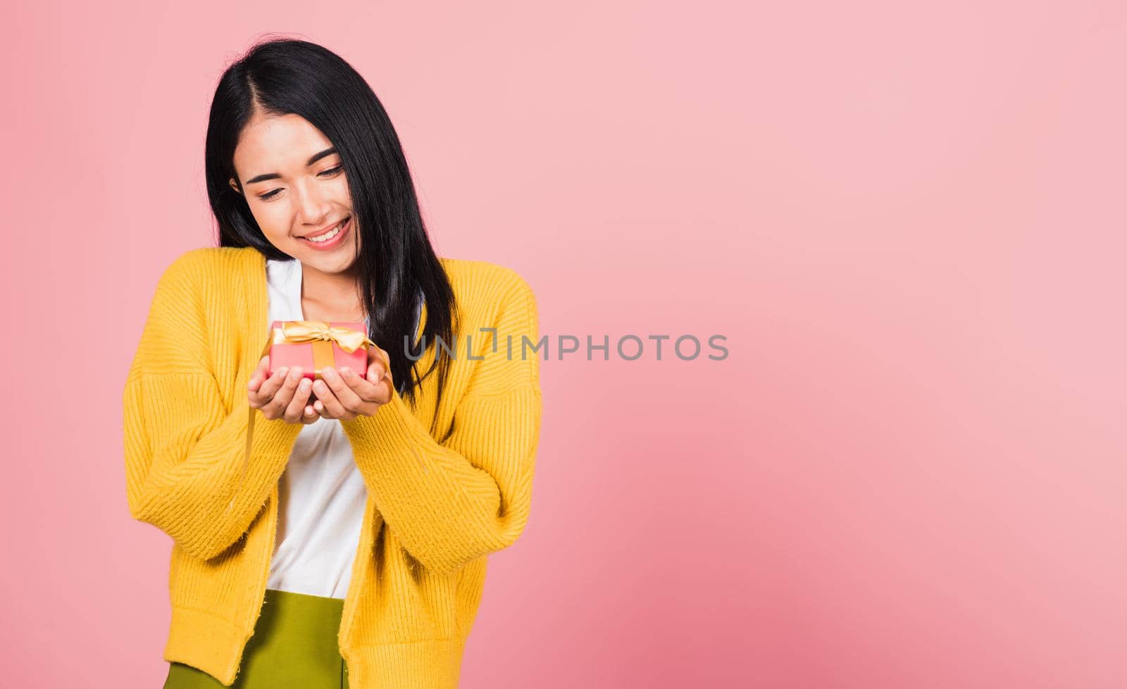 woman smiling holding small gift box on hands by Sorapop