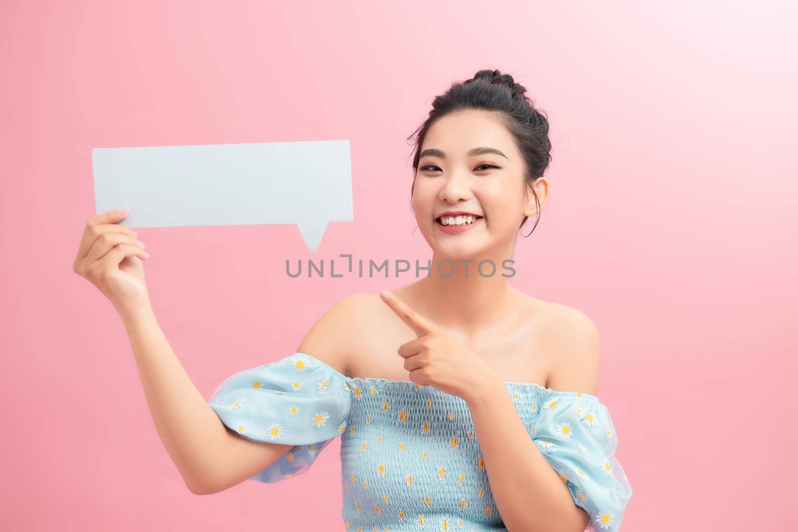 Happy Asian Girl Having Idea Holding Blank Speech Bubble Smiling on pink background