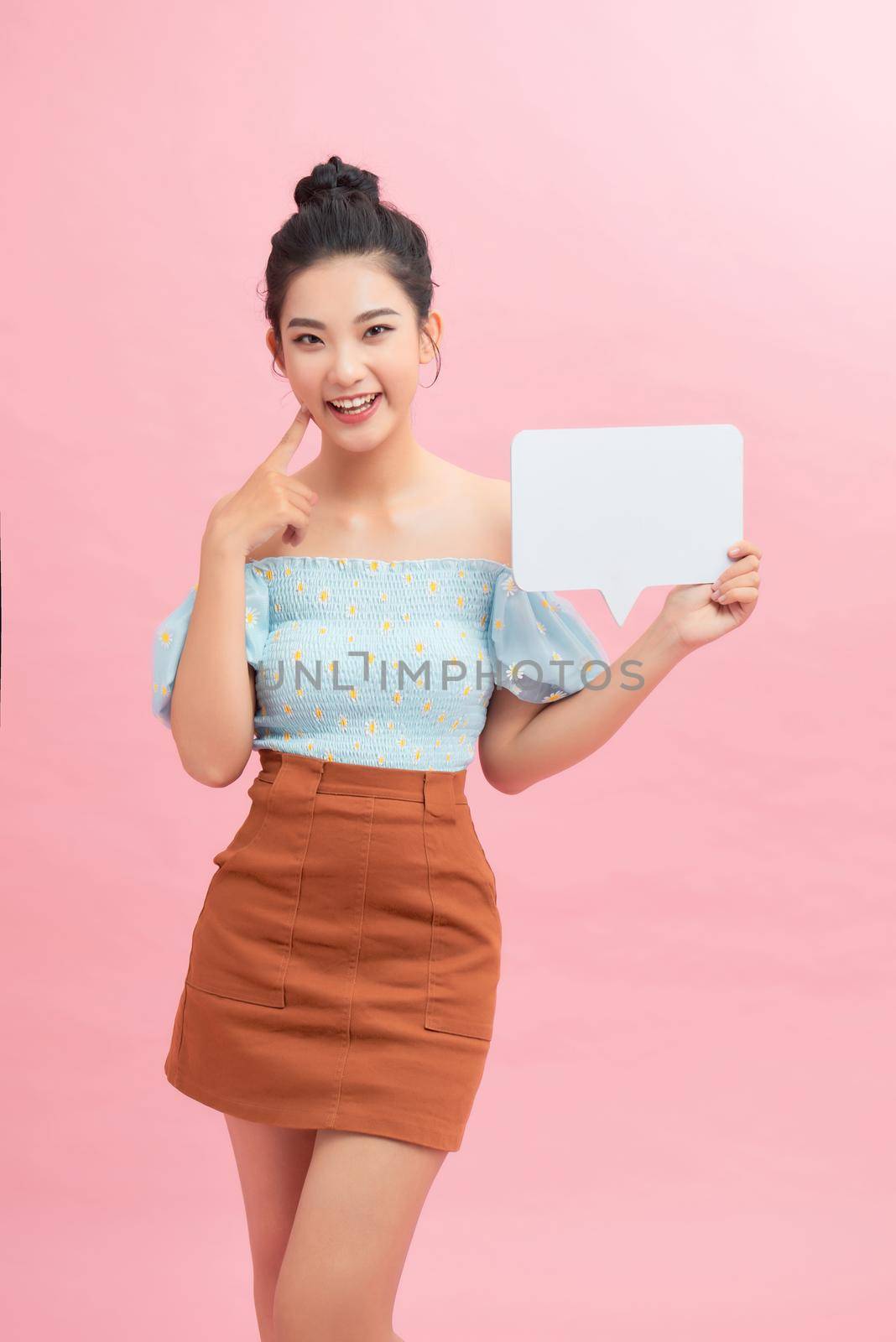 Happy Asian Girl Having Idea Holding Blank Speech Bubble Smiling on pink background