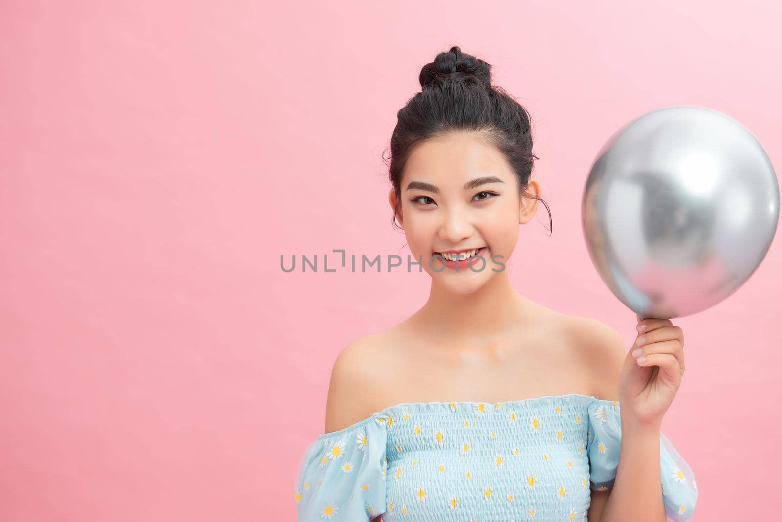 beautiful woman holding balloon on pink background by makidotvn