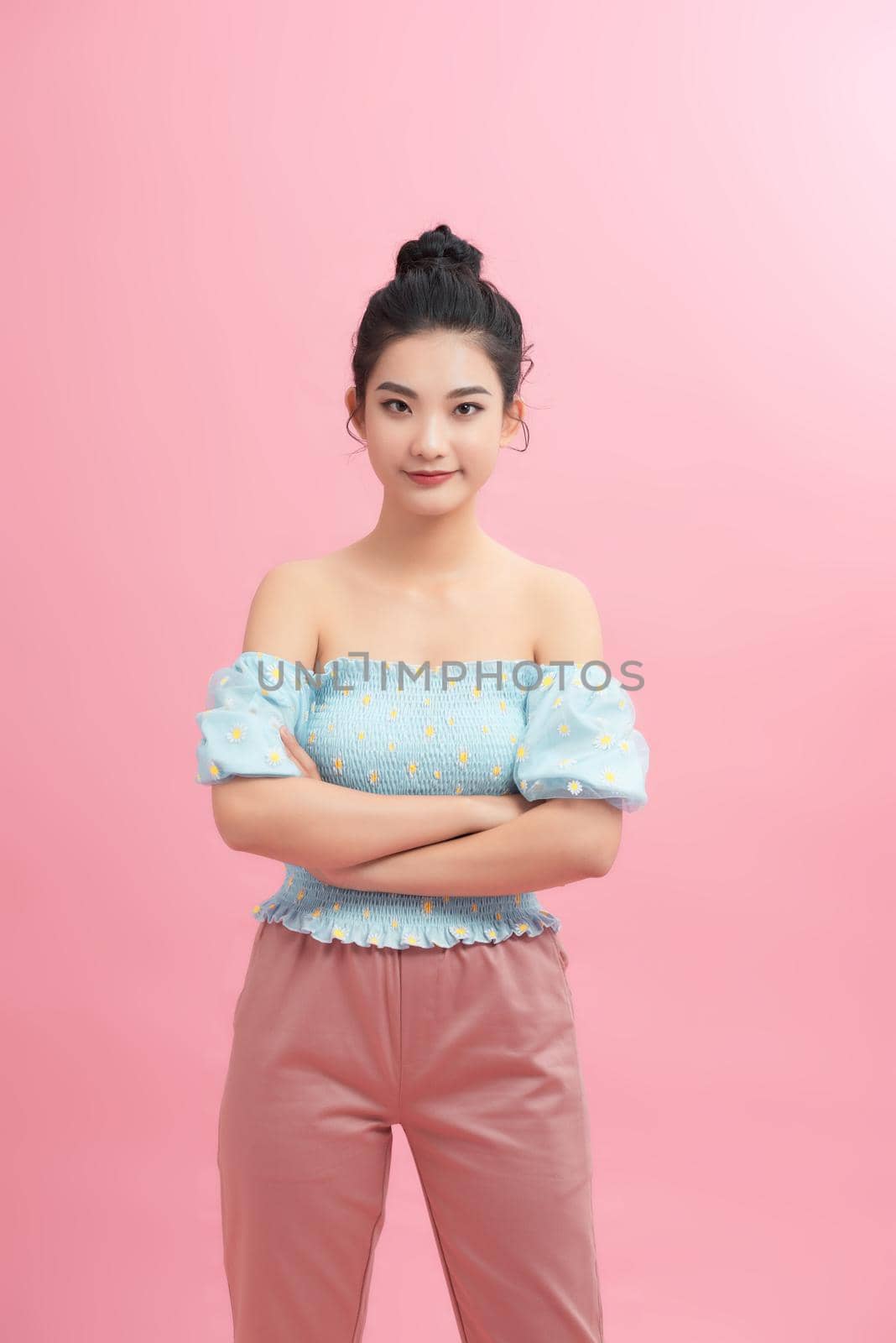 Portrait of charming girl folded arms isolated over pink pastel color background by makidotvn