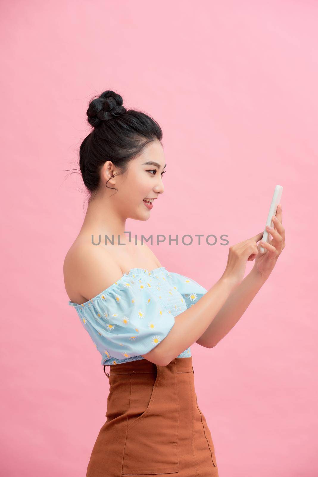 Attractive young asian woman chatting on web application by using tablet or smartphone, life style with modern technology.