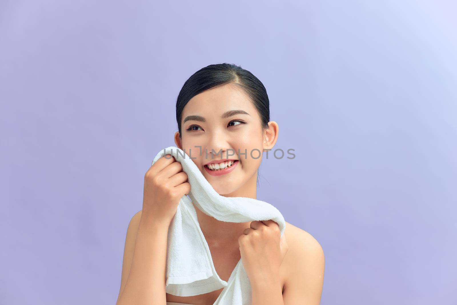 Woman cleaning facial skin with towel after washing face portrait by makidotvn