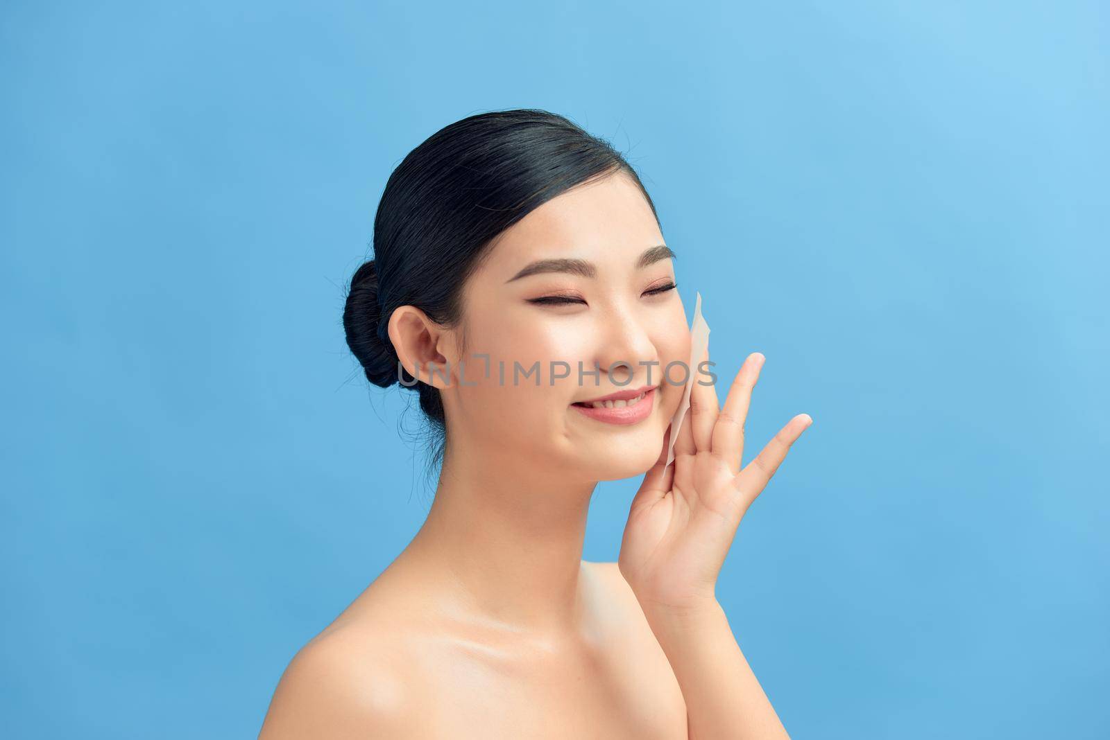 Skin Care. Woman Removing Oil From Face Using Blotting Papers.