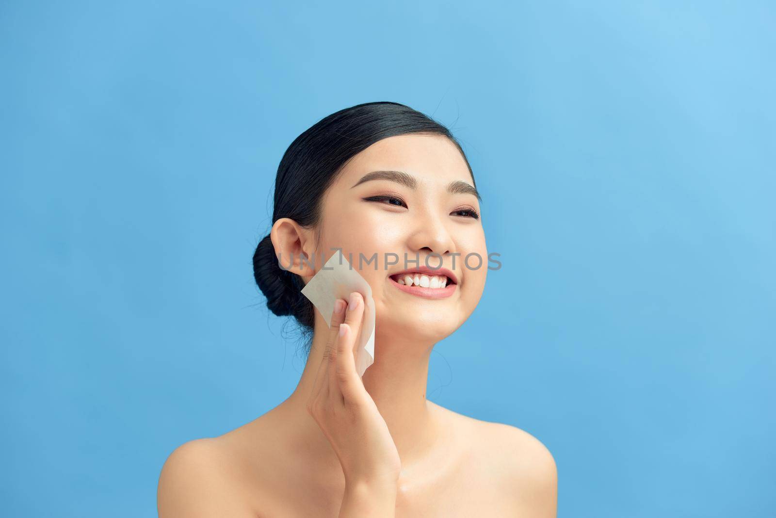 Beauty concept. Skin Care. Woman Removing Oil From Face Using Blotting Papers. by makidotvn