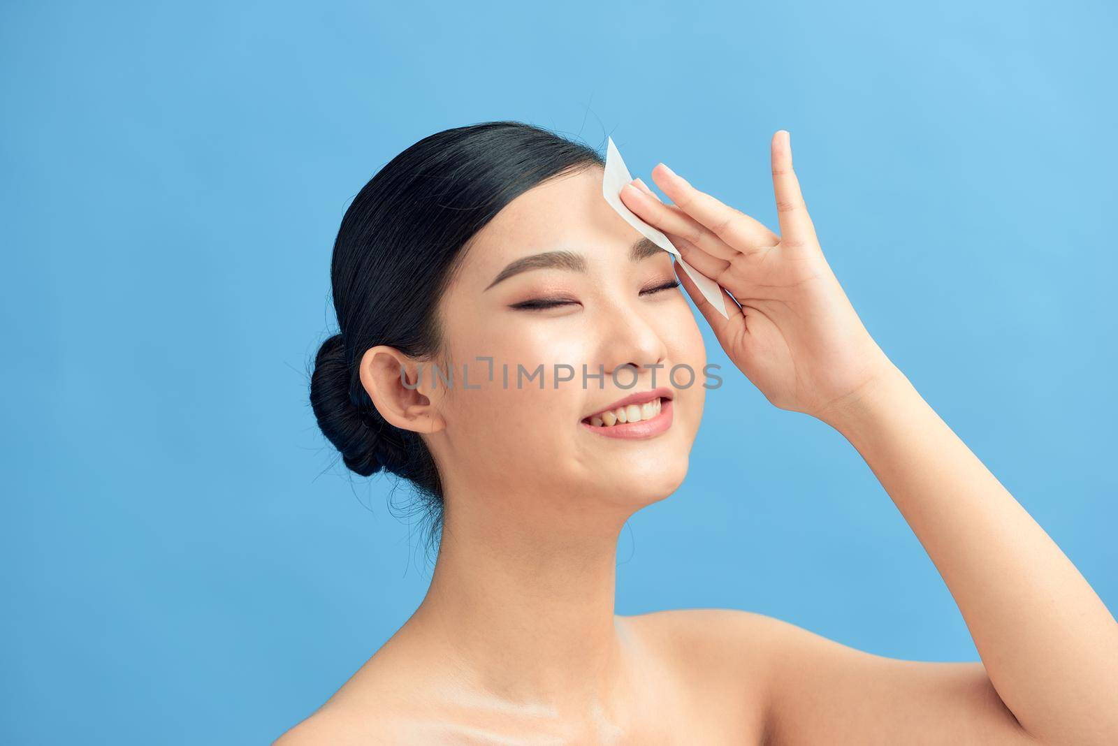 Beautiful Attractive Asian woman using Facial oil clean film to removal oily on face for face fresh skin feeling so fresh and clean, by makidotvn
