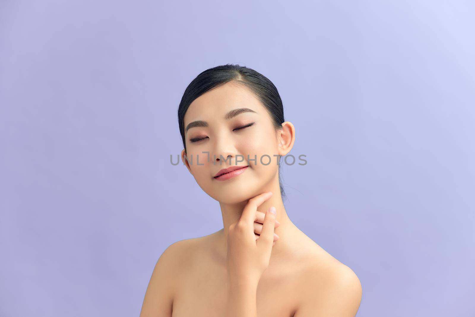 Closeup portrait of beauty asian woman with fair perfect healthy glow skin hand touching shoulder copy space,