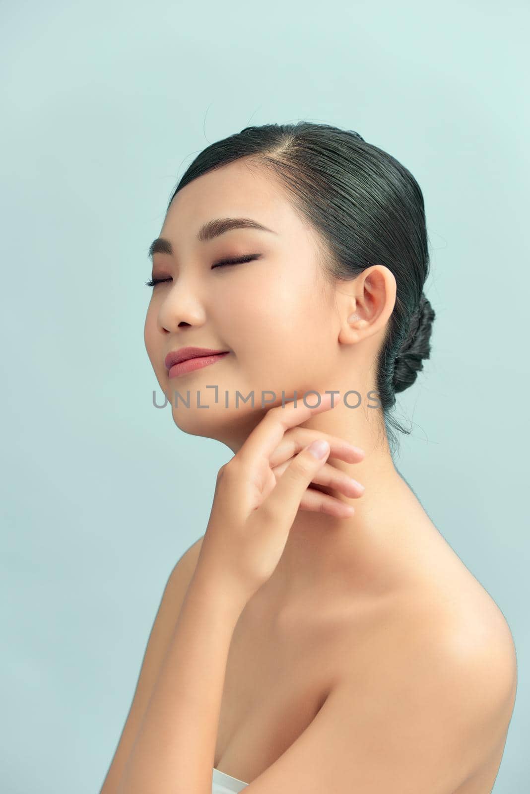 Closeup portrait of beauty asian woman with fair perfect healthy glow skin hand touching shoulder copy space,
