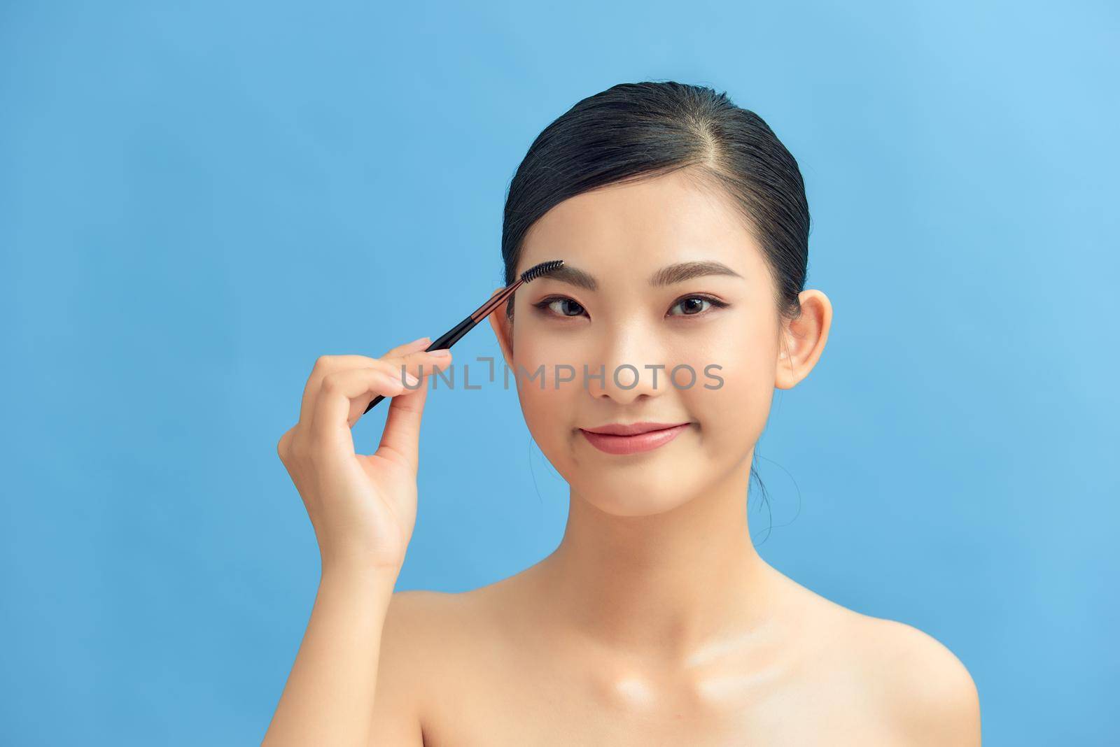 woman applying eyeshadow on eyelid using makeup brush by makidotvn