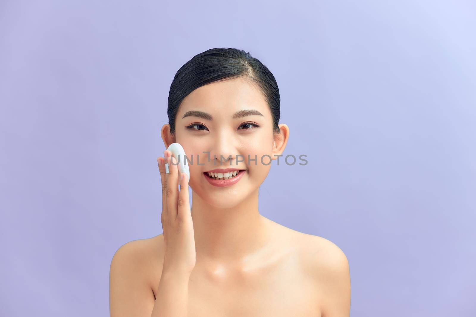 Woman applying cosmetic powder on face